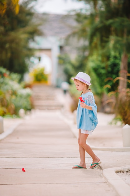 Schattig meisje ruiken kleurrijke bloemen op zomerdag