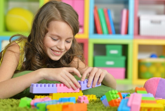 Schattig meisje speelt met kleurrijke plastic blokken