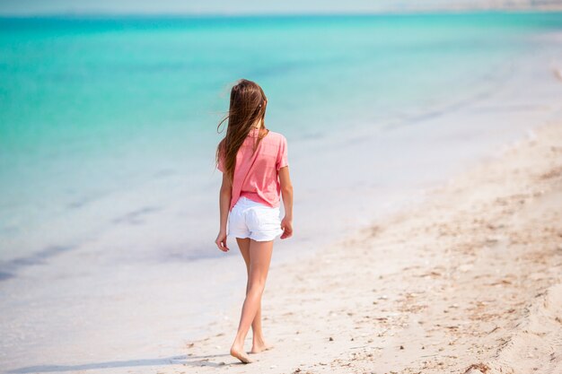 Schattig meisje veel plezier op tropisch strand tijdens vakantie