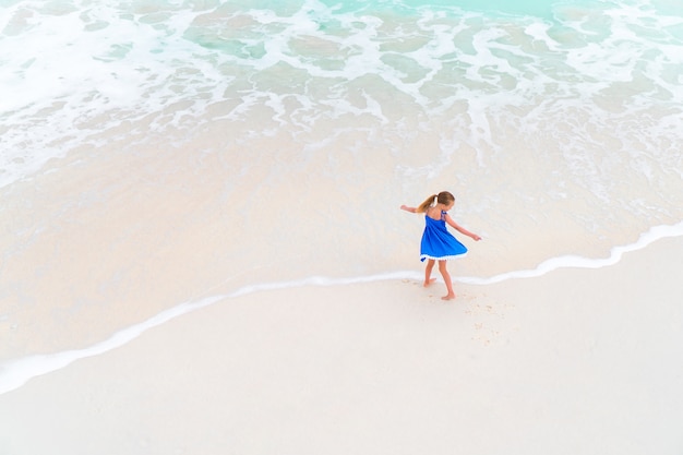 Schattig meisje veel plezier op tropisch strand tijdens vakantie