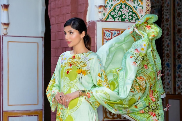 Schattig modelmeisje landschap zwaaiend met Dupatta op oude plaats met Desi-jurk