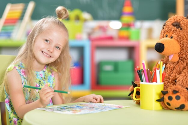 Schattig mooi klein meisje tekenen aan tafel