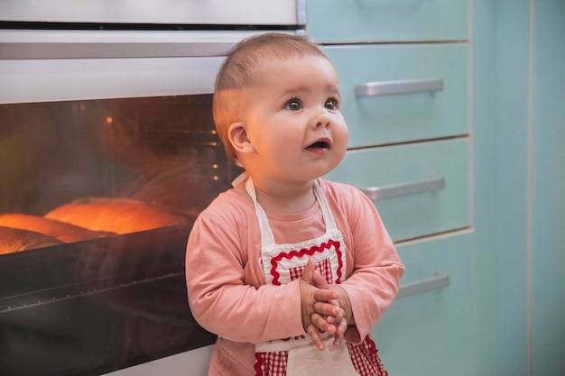 Schattig pasgeboren meisje in een schort bereidt taarten