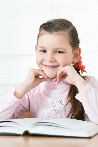 Schattig schoolmeisje aan tafel zitten en huiswerk maken