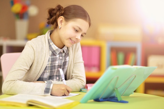 Schattig schoolmeisje huiswerk op haar kamer