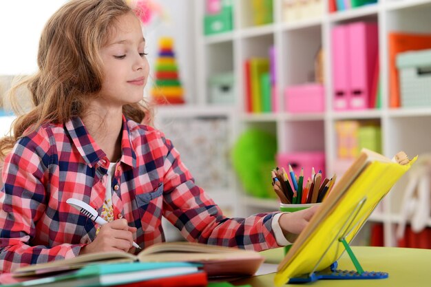 Schattig tienermeisje doet huiswerk in haar kamer