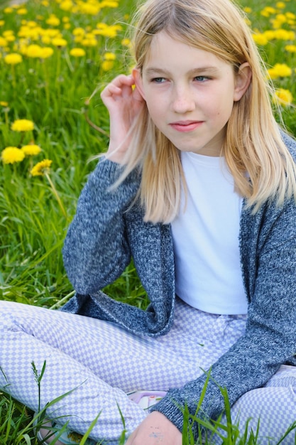 Foto schattig tienermeisje in een zomerveld met paardebloemen