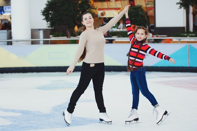 Schattig tienermeisje leert binnenshuis schaatsen op het ijs in het winkelcentrum