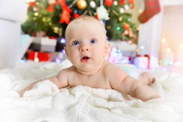 Schattige baby bij open haard en kerstboom thuis