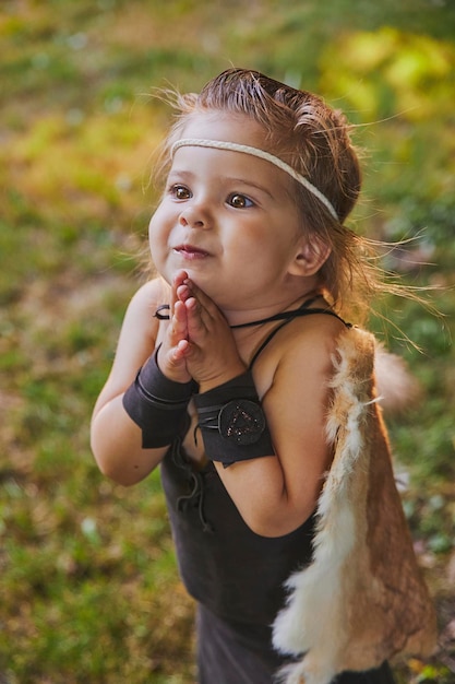 Schattige baby gekleed in de kleren van primitieve mensen