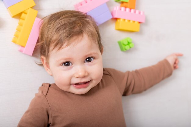 schattige baby in bruin shirt die met speelgoed speelt kaart banner ruimte voor tekst