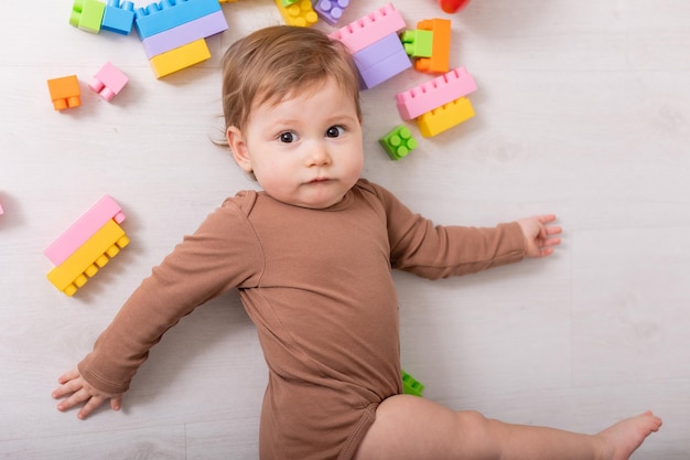 Schattige baby in bruin shirt spelen met speelgoed kaart banner ruimte voor tekst foto van hoge kwaliteit