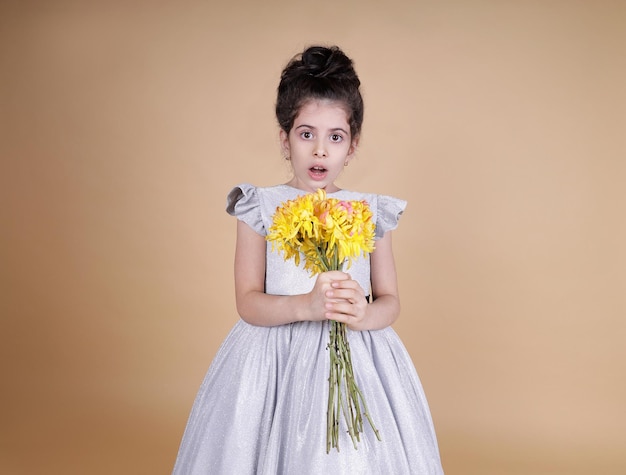 Schattige baby in een feestelijke jurk en bloemen