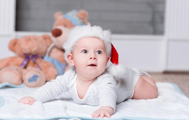 Schattige baby in kerstmuts op kerstavond