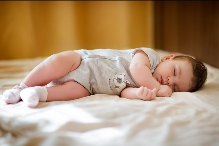 Foto schattige baby in lichte kleren, liggend op de bank en slapen.