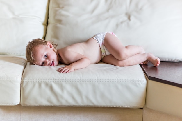 Schattige baby in luiers liggend op de Bank