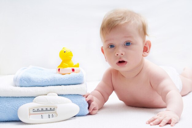 Schattige baby met bad accessoires in het bed