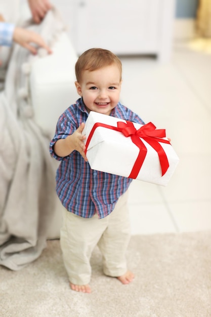 Schattige baby met geschenkdoos in de kamer