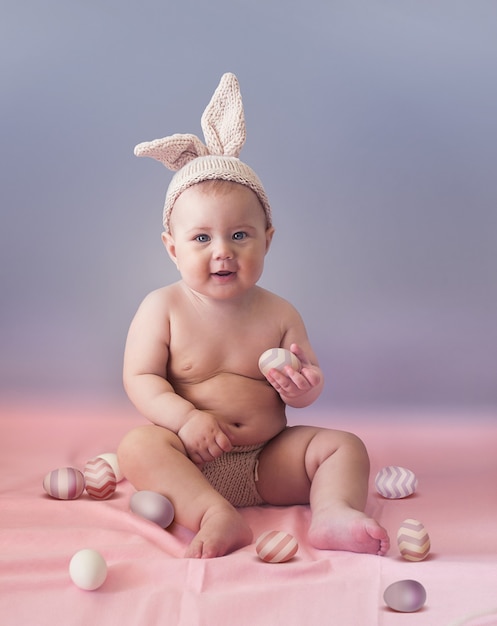 Schattige baby met kleurrijke paaseieren - een mooie kerstkaart