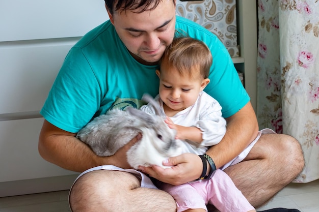 Schattige baby speelt met een plastic bord aan tafel klein kind verwent zich daarna in een kinderstoel