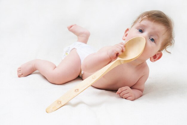 Schattige baby spelen met een grote houten lepel