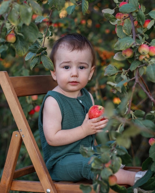 Schattige baby van één jaar in de appelboomgaard