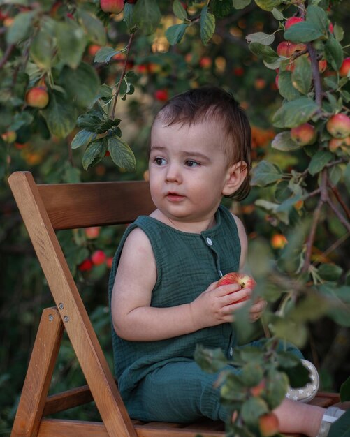 Schattige baby van één jaar in de appelboomgaard