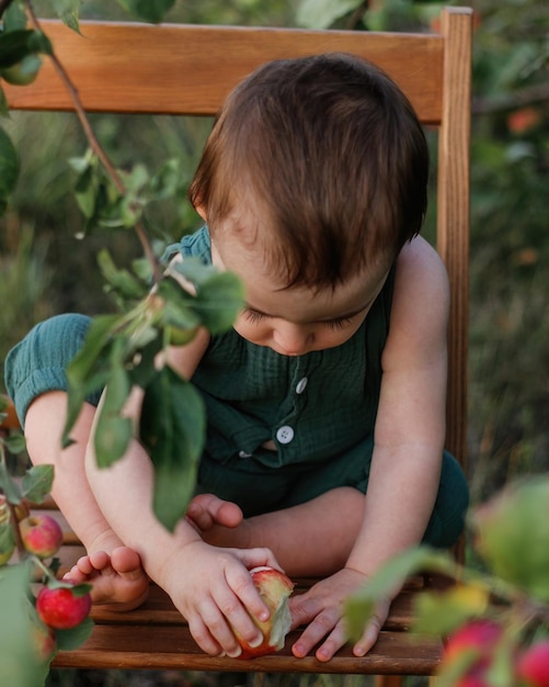 Schattige baby van één jaar in de appelboomgaard