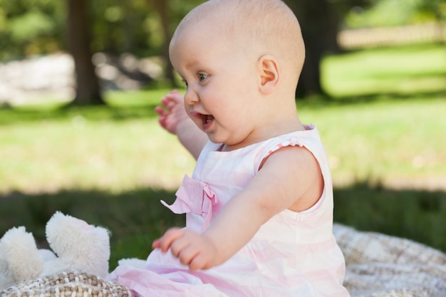 Schattige baby zittend op deken in het park