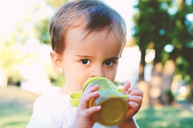 Schattige babyjongen consumptiemelk fles