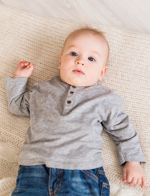 Schattige babyjongen in witte zonnige slaapkamer.