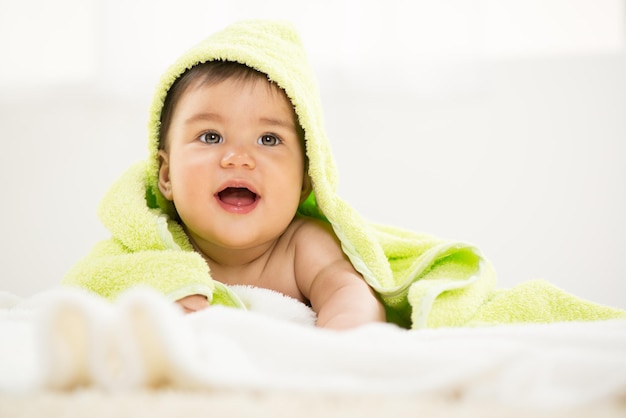 Schattige babyjongen liggend onder een handdoek