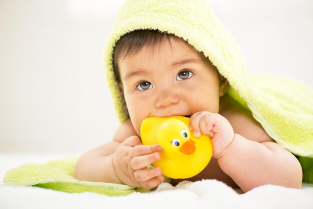 Schattige babyjongen liggend onder een handdoek