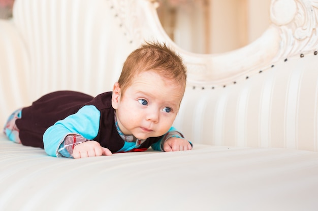 Schattige babyjongen liggend op buik in de slaapkamer