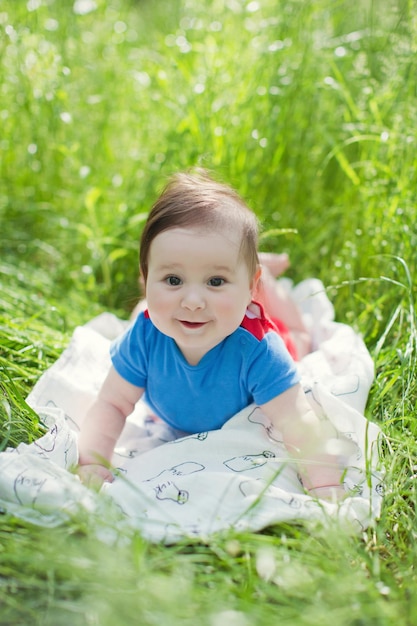 Schattige babyjongen liggend op een gras in het park