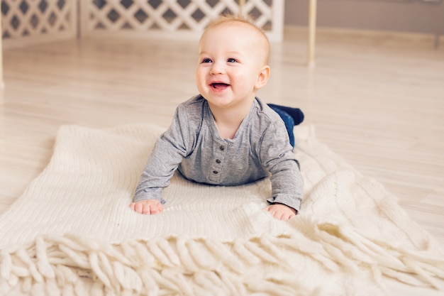 Schattige babyjongen op blauw lachen met moeder