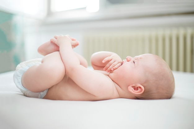 Schattige babymeisje huilen op het bed