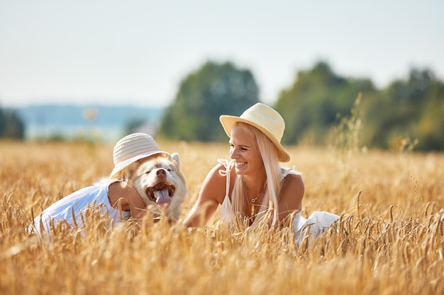 Schattige babymeisje met moeder en hond op tarweveld. Gelukkig jong gezin genieten van tijd samen in de natuur.