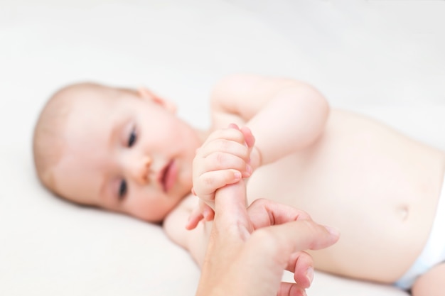 Schattige babymeisje moeders vinger te houden