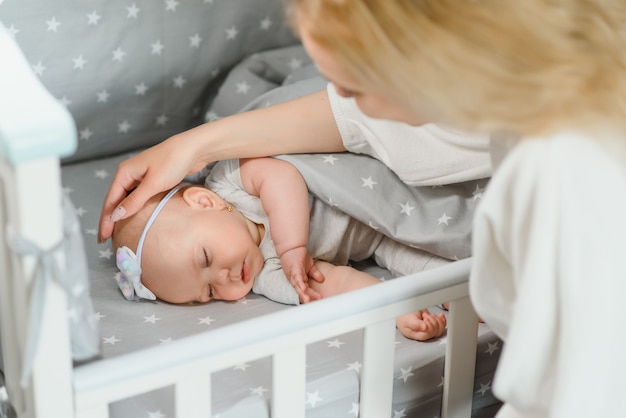 Schattige babymeisje slapen in de wieg. Klein kind met een dutje in bed. Baby kind rust in de kinderkamer