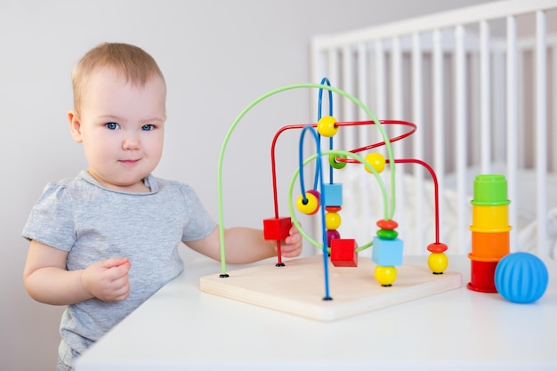 Schattige babymeisje spelen met kleurrijk speelgoed op tafel