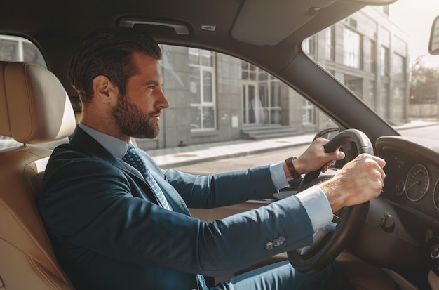 Schattige bebaarde man die een auto bestuurt op de stadsweg