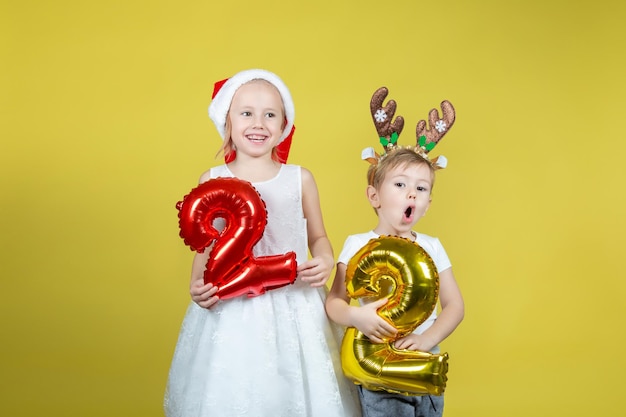 Schattige blanke kinderen houden ballonnen met cijfers vast en maken grappige gezichten