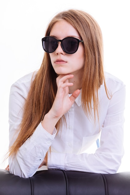 Foto schattige blonde houdt de zonnebril in de studio op een witte achtergrond. isolatie.