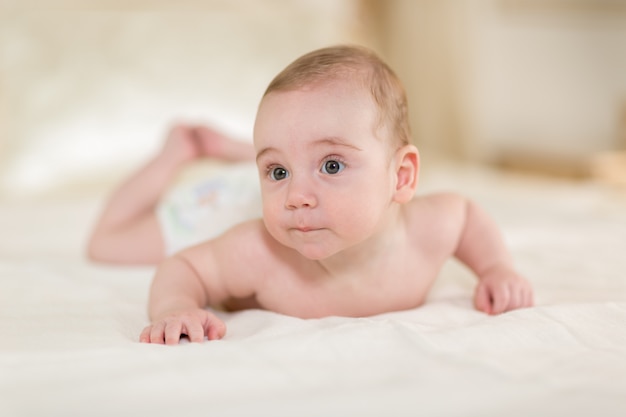 Schattige en kleine babyjongen in het bed