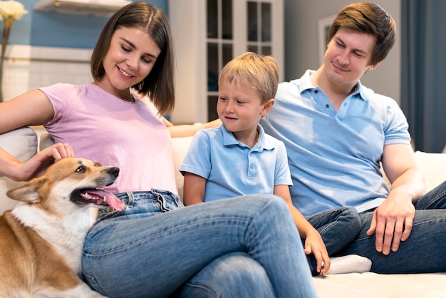 Foto schattige familie spelen met zoon en hond