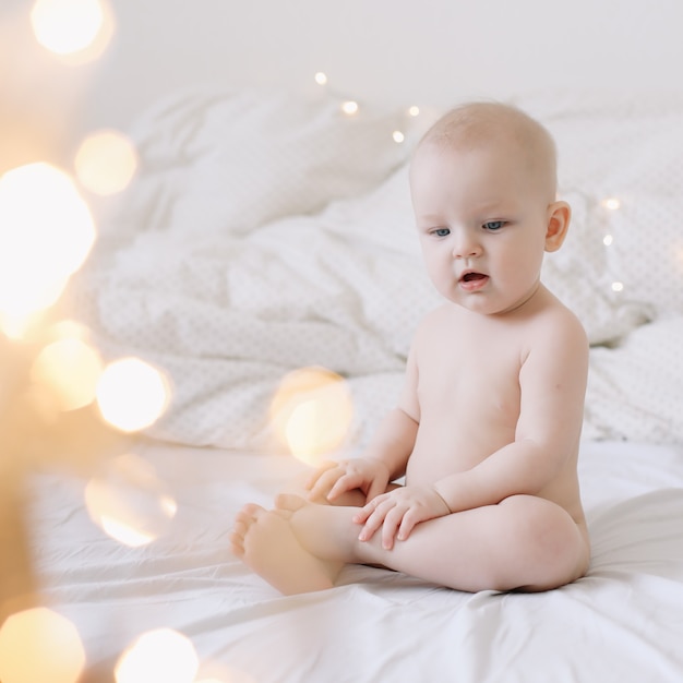 Schattige gelukkig lachende baby zit op het bed