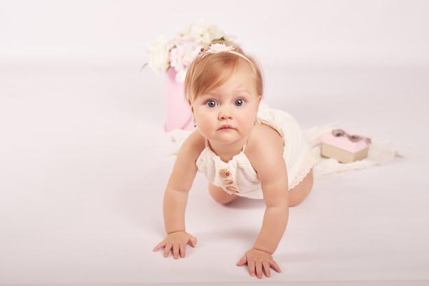 Schattige grappige baby met bloemen. Schattige babymeisje.