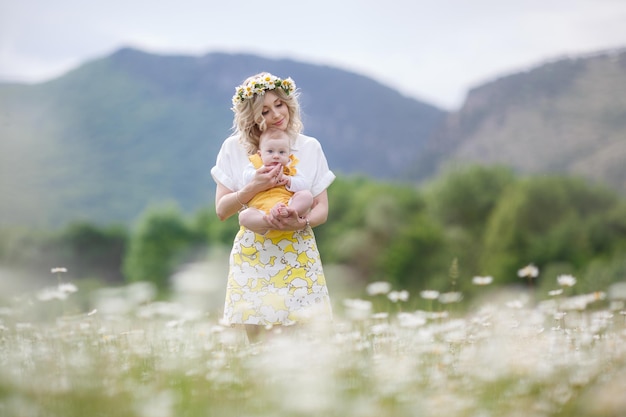 schattige jonge vrouw met baby in kamille veld