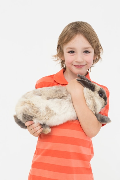 Schattige jongen bedrijf konijn op witte achtergrond